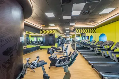 a gym with rows of treadmills and ellipticals at Redesigned High-Rise 1BR Near Key Landmarks, Elite Residence, Dubai Marina by Deluxe Holiday Homes in Dubai