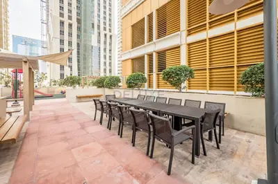 a black dining table and chairs on a patio at Redesigned High-Rise 1BR Near Key Landmarks, Elite Residence, Dubai Marina by Deluxe Holiday Homes in Dubai