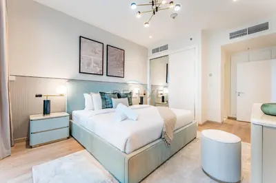 a bedroom with a large bed with a blue headboard at Redesigned High-Rise 1BR Near Key Landmarks, Elite Residence, Dubai Marina by Deluxe Holiday Homes in Dubai