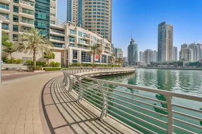 a walkway next to a body of water with buildings at Luxury new studio Dubai Marina 10min to the beach in Dubai