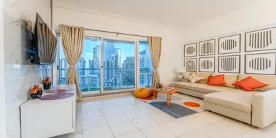 a living room with a couch and a large window at 1 BR Spacious Apartment - JLT in Dubai