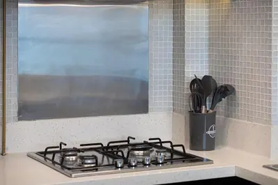 a stove top in a kitchen with a cup of utensils at Bay's Edge, Luxury Canal View 2BR in Business Bay in Dubai