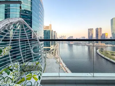 a balcony with a view of a river and buildings at Bay's Edge, Luxury Canal View 2BR in Business Bay in Dubai