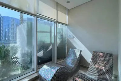 two chairs in a room with a large window at Bay's Edge, Luxury Canal View 2BR in Business Bay in Dubai