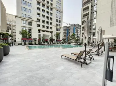 a patio with chairs and a pool in a building at Spacious 3BR, Private Beach Access in Dubai