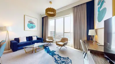 a living room with a blue couch and a large window at Locations I Avani Palm View I Luxury 2 Bedroom I Sea View I Pool, Gym, Parking, Wi-Fi in Dubai