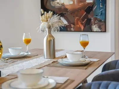 a wooden table with glasses of wine and a vase with flowers at Palm & Sea View Beach Acess JBR walk Skydive clubs in Dubai