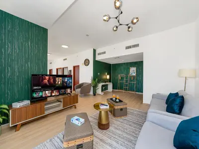 a living room with a couch and a flat screen tv at Palm & Sea View Beach Acess JBR walk Skydive clubs in Dubai