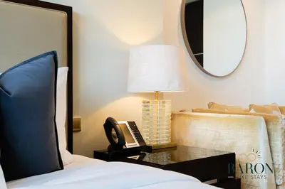 a bedroom with a bed with a phone and a mirror at The Chic in Dubai