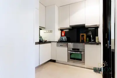 a kitchen with white cabinets and stainless steel appliances at The Chic in Dubai