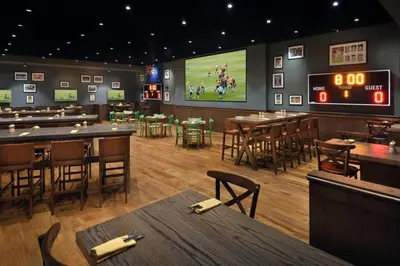 a restaurant with tables and a football game on the screen at The Chic in Dubai