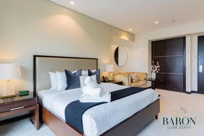 a bedroom with a large bed and a living room at The Chic in Dubai