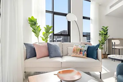 a living room with a white couch with pillows at Silkhaus Highfloor 1BDR in 15 Northside Tower in Dubai