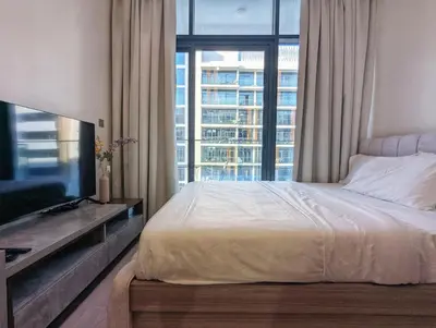 a bedroom with a bed and a large window at Fully Furnished Modern Studio Apartment Nearby Meydan Racecourse in Dubai