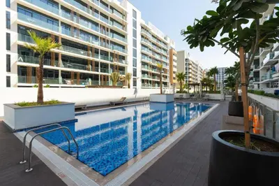 a swimming pool in front of a building at Fully Furnished Modern Studio Apartment Nearby Meydan Racecourse in Dubai