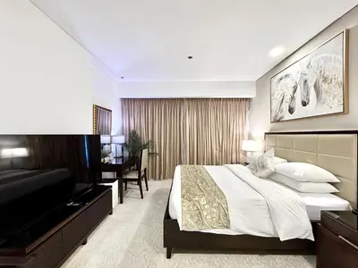a bedroom with a bed and a flat screen tv at Cosmos Living Studio at JW Marina in Dubai
