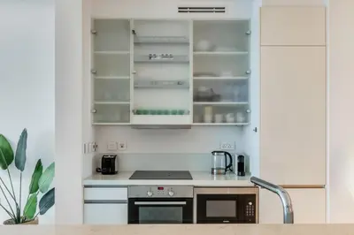 a kitchen with white cabinets and a stove top oven at GuestReady - Panoramic views from One JBR in Dubai