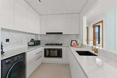 a white kitchen with a washer and dryer at GuestReady - Modern retreat in JVC in Dubai