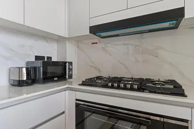 a kitchen with a stove and a microwave at GuestReady - Modern retreat in JVC in Dubai