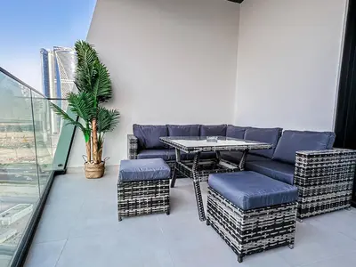 a room with a table and chairs on a balcony at Skyline Oasis - Business Bay with Burj Khalifa Vie in Dubai