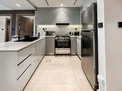 a kitchen with white cabinets and stainless steel appliances at Skyline Oasis - Business Bay with Burj Khalifa Vie in Dubai