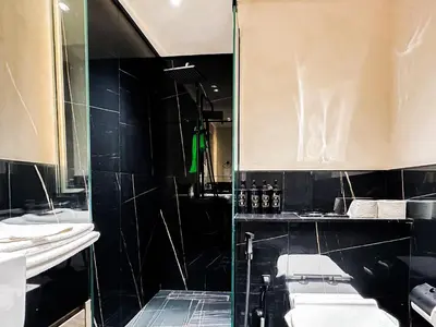 a bathroom with two sinks and a glass shower at Skyline Oasis - Business Bay with Burj Khalifa Vie in Dubai