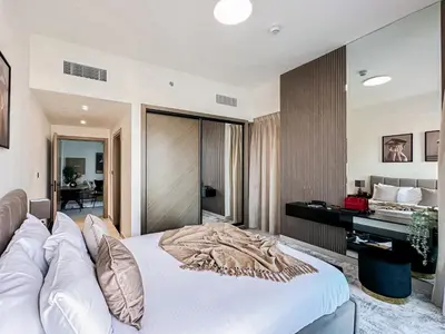 a bedroom with a large white bed and a desk at Skyline Oasis - Business Bay with Burj Khalifa Vie in Dubai