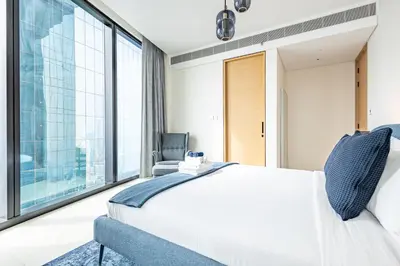a bedroom with a white bed and large windows at High-Floor Luxury 2BR, Sea View, Address JBR in Dubai