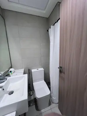 a bathroom with a toilet and a sink and a mirror at Azizi riviera in Dubai