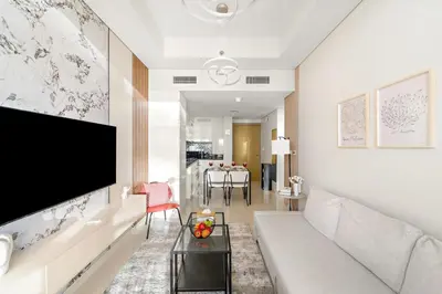 a living room with a couch and a flat screen tv at FIRST CLASS 1BR Luxe Comfort Stylish Design in Dubai