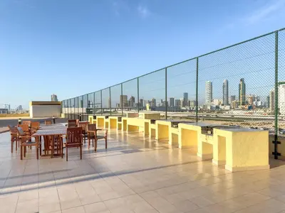 a cafeteria with tables and chairs on a roof at FIRST CLASS Studio Cozy & Chic Retreat in Dubai
