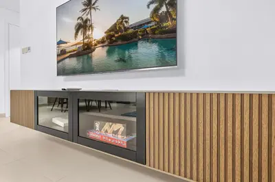 a flat screen tv sitting on top of a entertainment center at Spacious Dubai Apartment with Water Views and Luxury Amenities in Dubai