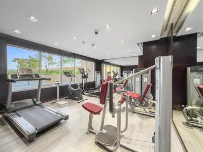 a gym with several treadmills and cardio machines at FIRST CLASS Studio Luxe Cozy Living in Dubai