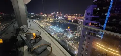 a view of a city at night from a building at Highend 2BR Palm Sea View with Pool and Nightlife Marina in Dubai
