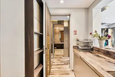 a hallway with a door leading into a bathroom with a sink at Highend 2BR Palm Sea View with Pool and Nightlife Marina in Dubai