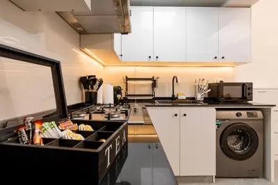 a kitchen with a stove top oven next to a washing machine at Dubai Marina - 1 BHK Stunning Apartment in Dubai