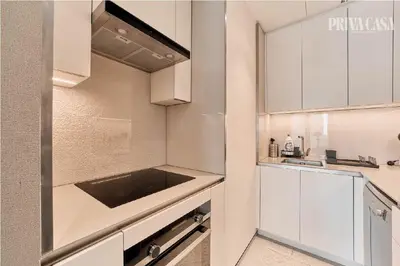 a small kitchen with white cabinets and a sink at PRIVACASA - The Address Beach Resort residences in Dubai