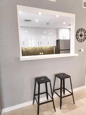 two stools in front of a kitchen with a mirror at Marina Bliss Luxe Stay with Waterfront and Palm Views in Dubai