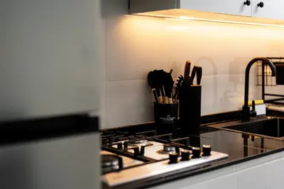 a kitchen counter with a stove with utensils at Dubai Marina - Lovely Studio Apartment in Dubai