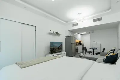 a white room with a kitchen and a living room at Dubai Marina - Lovely Studio Apartment in Dubai