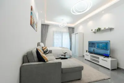 a living room with a couch and a tv at Dubai Marina - Lovely Studio Apartment in Dubai
