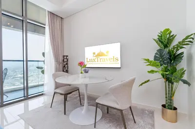 a white dining room with a white table and chairs at Aykon City Panoramic Skyline View in Dubai