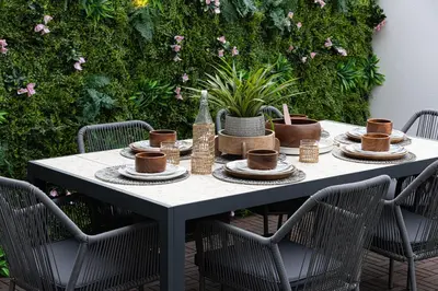 a table with cups and plates on it with chairs at Elegant 4BR Villa, Bali Pool Retreat, Ruba, A Ranches 3 in Dubai
