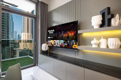 a living room with a tv and a window at 2BR Dubai Gem steps from Dubai Mall & Burj in Dubai
