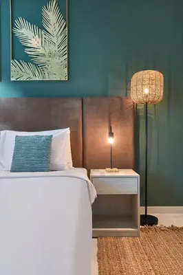 a bedroom with a bed and a table with a lamp at The Seven Palm with free rooftop pool & beach in Dubai