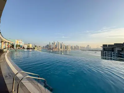 a large swimming pool with a view of the city at The Seven Palm with free rooftop pool & beach in Dubai
