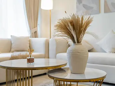a living room with a vase on a table and a couch at EMAAR GRANDE 1BR Downtown I Steps to Fountain & Dubai Mall in Dubai