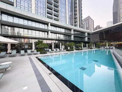 a large swimming pool in the middle of a building at EMAAR GRANDE 1BR Downtown I Steps to Fountain & Dubai Mall in Dubai