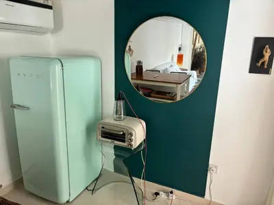 a room with a blue refrigerator and a mirror at Private Cottage with bbq area 5 min walk to beach! in Dubai