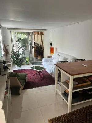 a living room with a bed and a table at Private Cottage with bbq area 5 min walk to beach! in Dubai